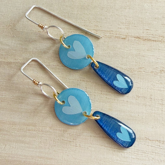 blue heart drop earrings on a wooden surface