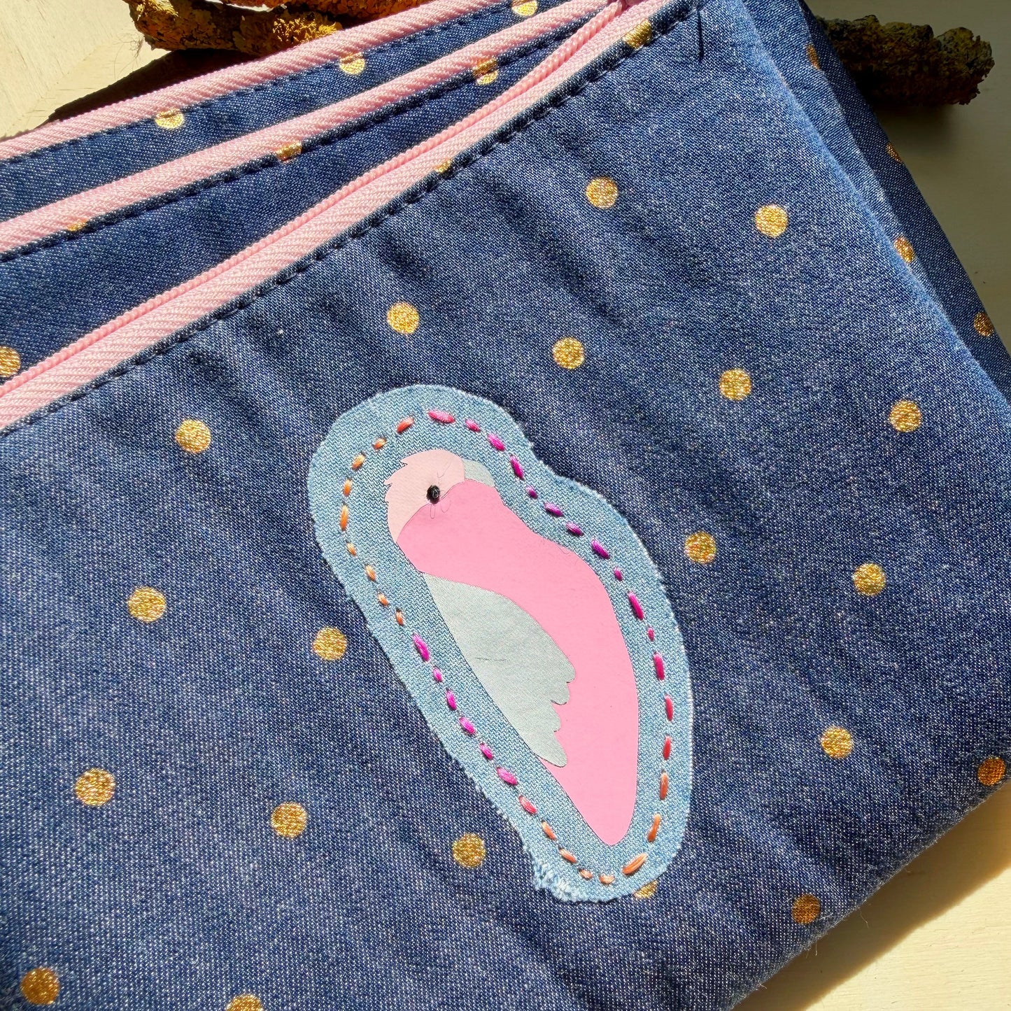 handmade blue denim pouch with gold polkadots featuring a galah and hand stiched embroidery detail
