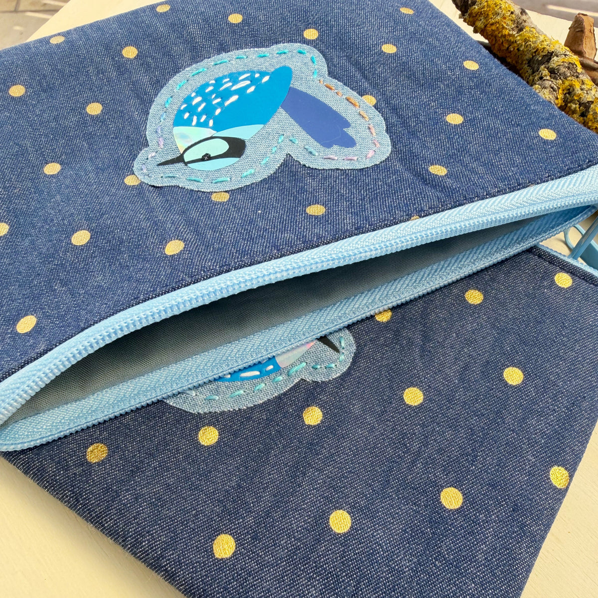 closeup of handmade zip pouch featuring a bright blue splendid fairy wren applique showing lining of interior