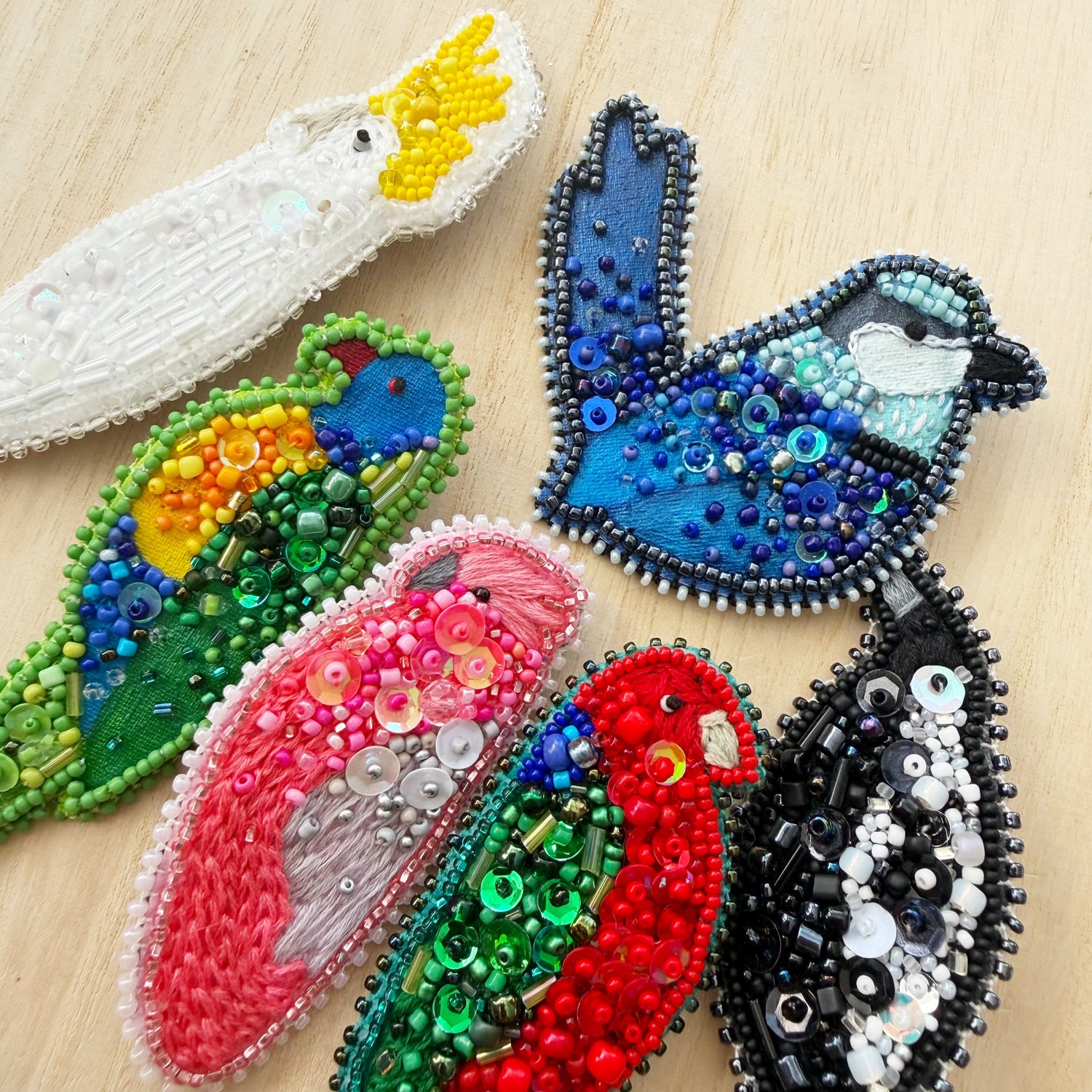 Group of colourful hand beaded bird brooches, including cockatoo, magpie, wren