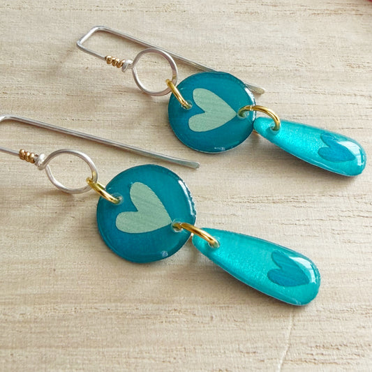 Aqua heart drop earrings on a wooden surface