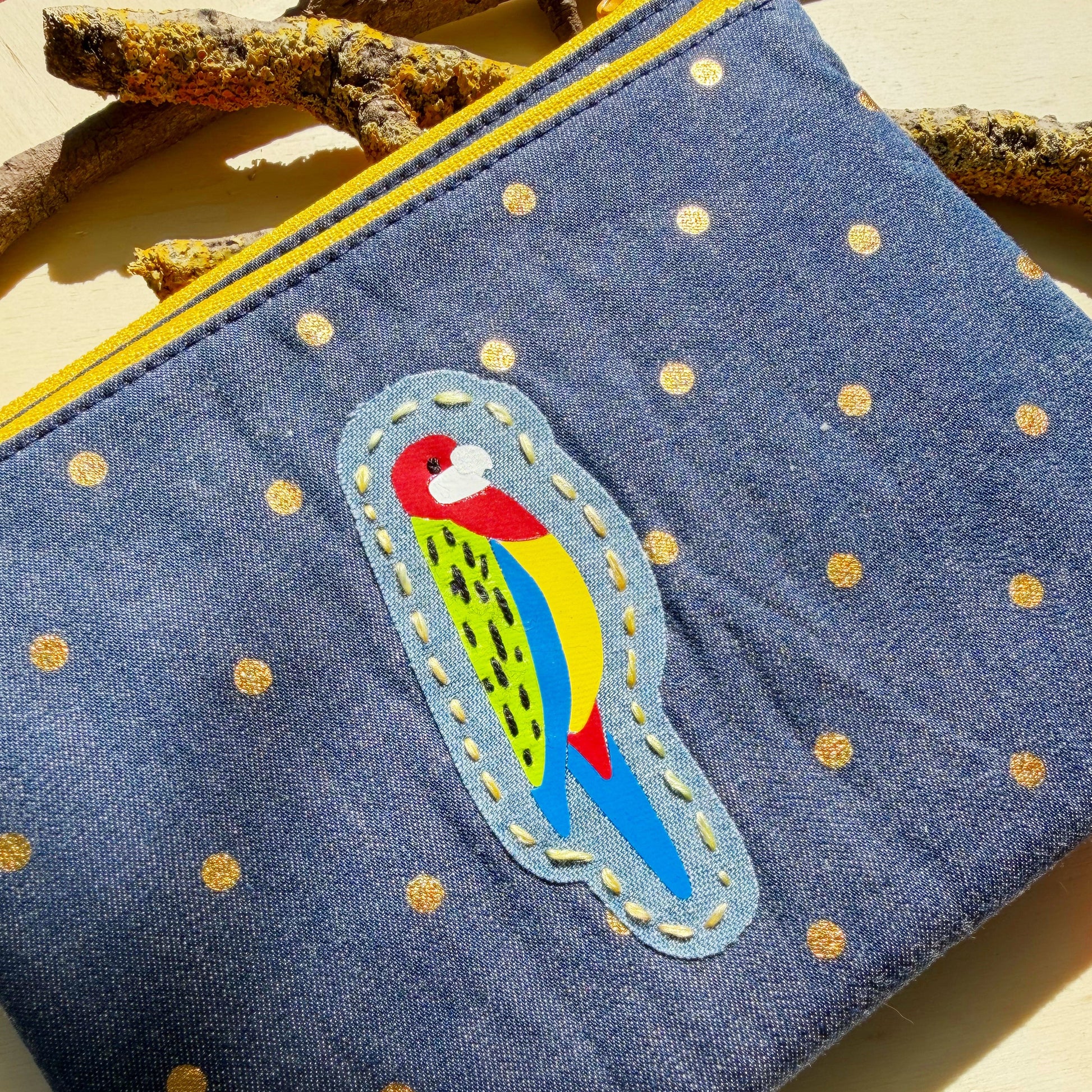 handmade zip pouch featuring eastern rosella bird design with closeup of hand stitched details