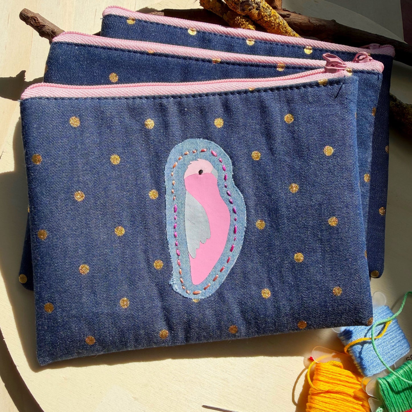 handmade blue denim pouch with gold polkdots featuring pink and grey galah and hand stitched detail