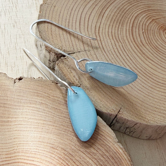 Blue teardrop earrings on a wooden surface