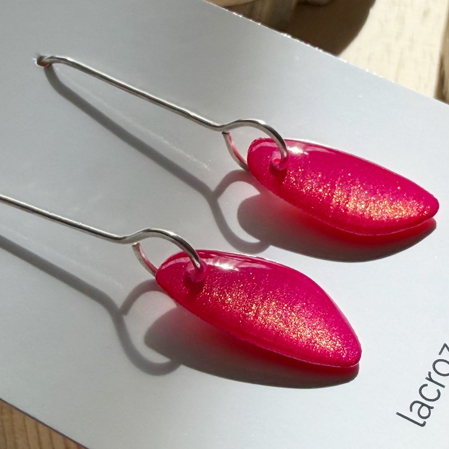 closeup of organic teardrop shaped drop earrings on business card